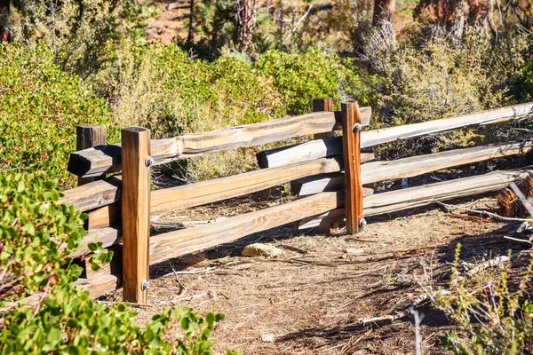 stock image Close up of a wooden fence along a forest path on a sunny autumn day. Lake Tahoe, CA, United States.