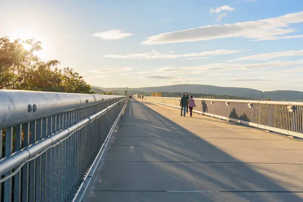 stock image People walking along an old railway bridge converted into a pedestrian and bicycle bridge at sunset in autumn. Poughkeepsie, NY, United States.