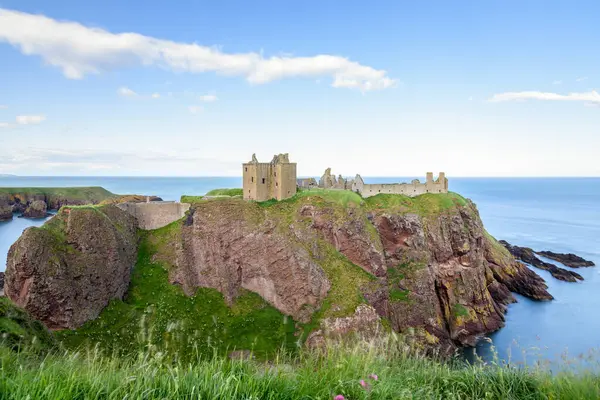 Dunnottar Clastle 'ın manzarası açık bir yaz gününde Stonehaven, İskoçya' nın parlaklığında kayalık bir çıkıntıya tünemişti.