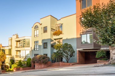 Güneşli bir sonbahar gününde San Francisco 'da dik bir cadde boyunca modern apartmanlar inşa edilir. Kaliforniya, ABD.
