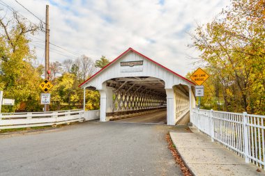 Bulutlu bir sonbahar gününde New Hampshire 'ın kırsal kesimindeki eski beyaz ahşap köprü. Wincester, NH, ABD.