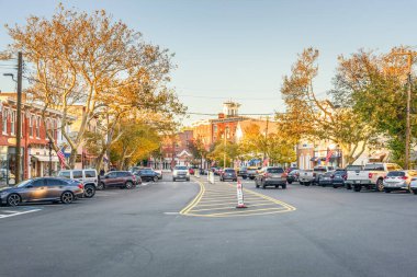 Sag Harbor, New York - 23 Ekim 2023: Günbatımında tarihi tuğla binalar ve ağaçlarla kaplı ana cadde manzarası. 1745 yılına kadar uzanan ana cadde Sag Limanı merkez merkezi olarak hizmet veriyor..