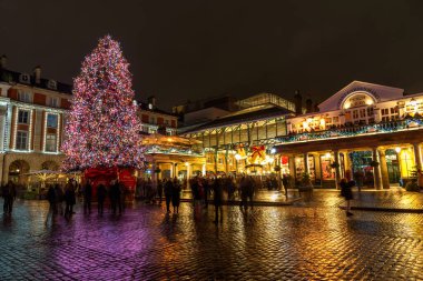 Londra, İngiltere - 1 Aralık 2024: İnsanlar Covent Garden Market 'in önündeki ışıklandırılmış Noel ağacının fotoğraflarını çekiyor