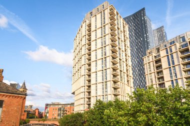 Yazın günbatımında şehrin yeniden inşasında yenilenen geleneksel tuğla binaların yanında modern apartman blokları. Castlefield, Manchester, İngiltere, İngiltere.