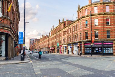 Manchester, İngiltere - 13 Temmuz 2023: Manchester şehir merkezinin batı kısmından aşağı yukarı kuzey-güney yönüne uzanan Deanbsgate boyunca uzanan tarihi binalar ve şalterler.