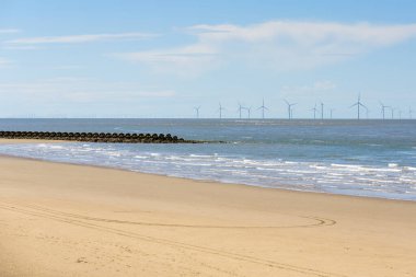 Kuzey İngiltere sahillerinde, açık bir bahar gününde ıssız bir kumsal açıklarında rüzgâr tarlası. New Brighton, Wallasey, İngiltere, İngiltere.