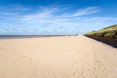 Güneşli bir yaz gününde Kuzey Denizi kıyısında büyük kumlu bir sahil. Wenduine, Belçika.