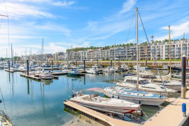 Tekneler, modern apartmanlarla dolu bir marinaya demirlemiş. Zeebrugge, Belçika.
