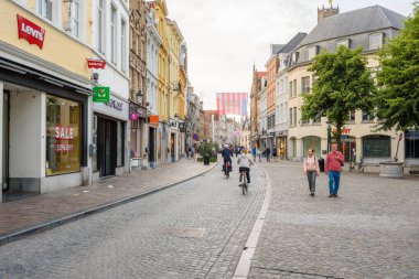 Bruges, Belçika - 11 Temmuz 2024: İnsanlar gün batımında Steenstraat caddesinde geziniyorlar. Grote Markt 'tan başlayıp Zuidzandstraat' ta sona eren Steenstraat, sadece en iyi alışveriş merkezleri değil, aynı zamanda mimari ve kültürel güzelliklerin de bulunduğu bir yer..