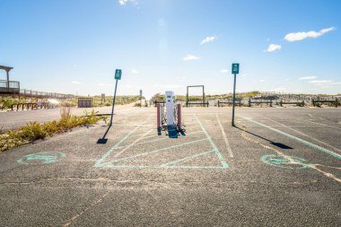 Güneşli bir sonbahar sabahında plaj boyunca terk edilmiş bir otoparkta elektrikli arabalar için şarj istasyonu. Long Island, New York, ABD.