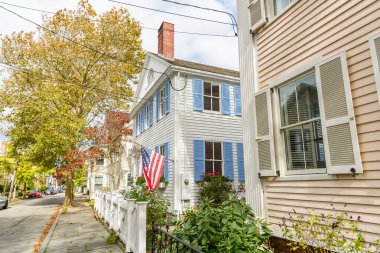 Güneşli bir sonbahar gününde New England 'ın eski bir şehir merkezindeki ağaç sıralı bir cadde boyunca tarihi ahşap kasaba evleri. Stonington, CT, ABD.