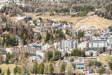Güneşli bir bahar gününde İsviçre 'nin Saint Moriz kentindeki Mountainside konutları ve ticari binalar