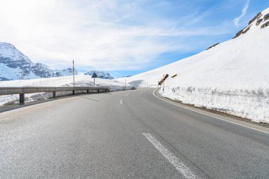 Baharın başında karlı bir dağ geçidinin üzerinde terk edilmiş viraj yolu. Bernina Geçidi, İsviçre.
