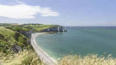 Güneşli bir yaz gününde etretat kıyıları ve uçurumlar. Hareket eden bulutlar ve insanlar. Normandiya, Fransa - zaman aşımı