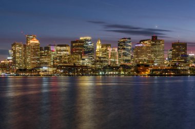 Boston şehir merkezinin görkemli manzarası ve sonbaharda alacakaranlıkta liman manzarası. MA, ABD.