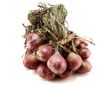 Beyaz arka planda kırpma ile büyük bir demet arpacık soğanı.