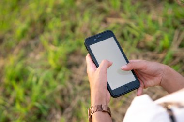 Parkta akıllı telefon kullanan kadın..