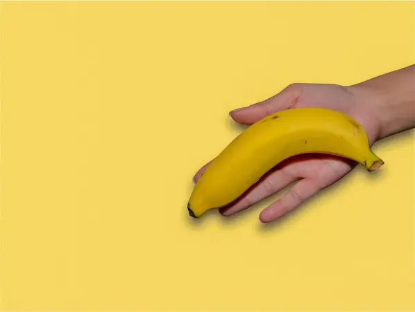 Mano Mujer Sosteniendo Plátano Sobre Fondo Amarillo — Foto de Stock