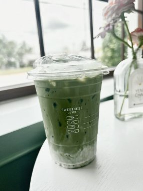 Beyaz arka planda cam bir kavanozda yeşil çay