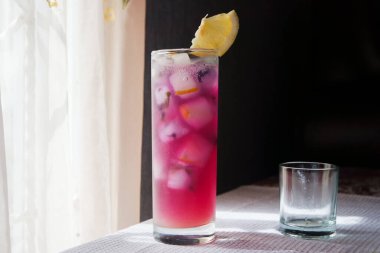 Dilimlenmiş limonlu Kelebek Bezelye Çayı. Pencere Önünde Kelebek Bezelye Çay Üssü ile Limonata.