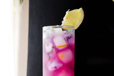 Dilimlenmiş limonlu Kelebek Bezelye Çayı. Pencere Önünde Kelebek Bezelye Çay Üssü ile Limonata.