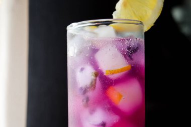 Dilimlenmiş limonlu Kelebek Bezelye Çayı. Pencere Önünde Kelebek Bezelye Çay Üssü ile Limonata.