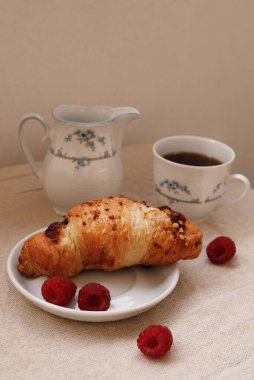 Masada ayçöreği olan bir fincan kahve.