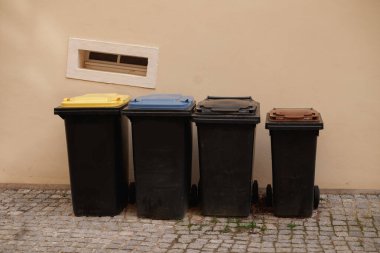 Different dustbins for waste separation. Recycling in germany. Yellow, blue and brown caps.