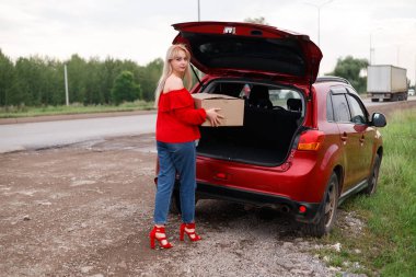 girl puts the box in the trunk clipart