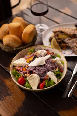 Salata soslu pirzola, kırmızı şarap.