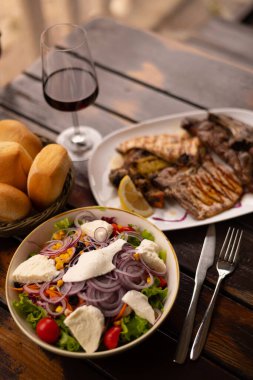 Salata soslu pirzola, kırmızı şarap.