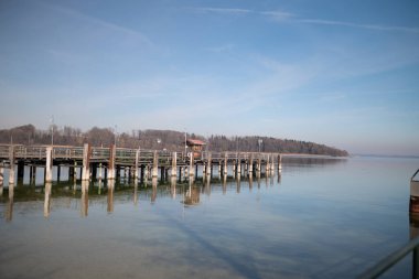 Kışın Almanya, Bavyera, Chiemsee 'deki tahta iskele. Güneşli bir gün, arka planda Bavyera Alpleri