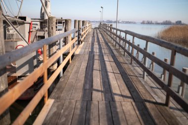 Kışın Almanya, Bavyera, Chiemsee 'deki tahta iskele. Güneşli bir gün, arka planda Bavyera Alpleri