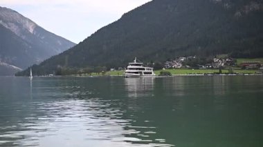 İtalya 'daki Garda Gölü. Isola del Garda 'nın sinematik manzarası ve içinde insanların olduğu lüks bir motorlu tekne. Lüks bir villanın deniz manzarası ve yanında da yeşil bir bahçe..