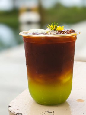 iced americano with kiwi and ice cubes in a glass on the wooden table, stock photo