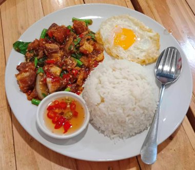 Tavada kızarmış domuz göbeği ve Tayland fesleğenli pilav.