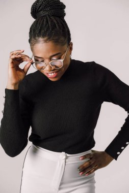 Beyaz arka planda gülümseyen ve mutlu siyah kadın portresi, siyah bluz giyen Afrikalı Amerikalı kadın.