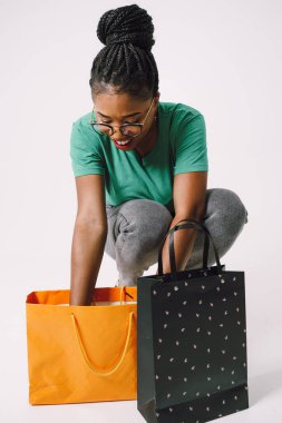 Alışveriş Konsepti - Genç ve çekici Afrikalı bir kadının portresi Alışveriş torbalarıyla gülümsüyor.