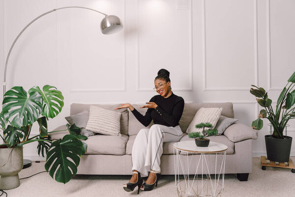 Портрет привлекательной черной женщины улыбающейся и счастливой на белом фоне, афроамериканки в черном топе