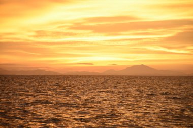 Akşam gökyüzü ve gün batımı denizde.