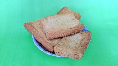 Yeşil bir yüzey üzerinde bir tabak kızarmış ekmek.