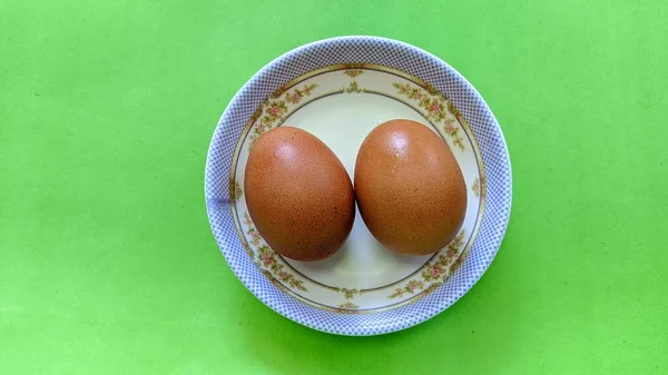 Bovenaanzicht Van Twee Rauwe Bruine Eieren Een Plaat Geïsoleerd Groene — Stockfoto