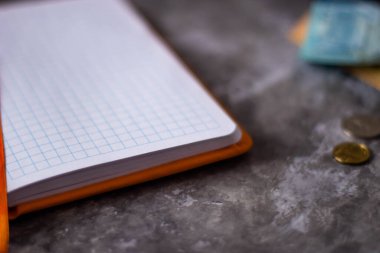 Tenge. Kazak parası. Gri arka planda bir defter. Banknotlar ve madeni paralar. Yüksek kalite fotoğraf