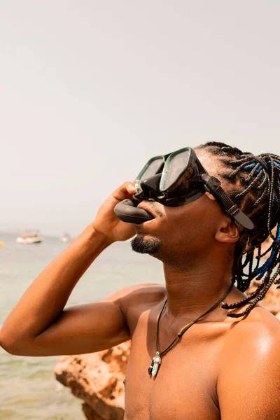 Genç Afro-Amerikalı çocuğun dikey fotoğrafı. Yazın ilk kez plajda dalış takımını deniyor.