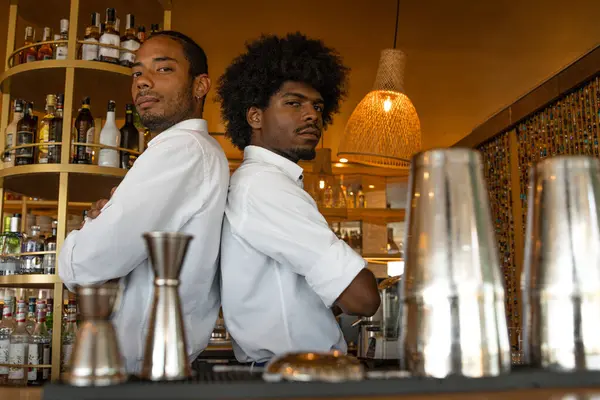 Barın arkasında iki Latin barmen var.