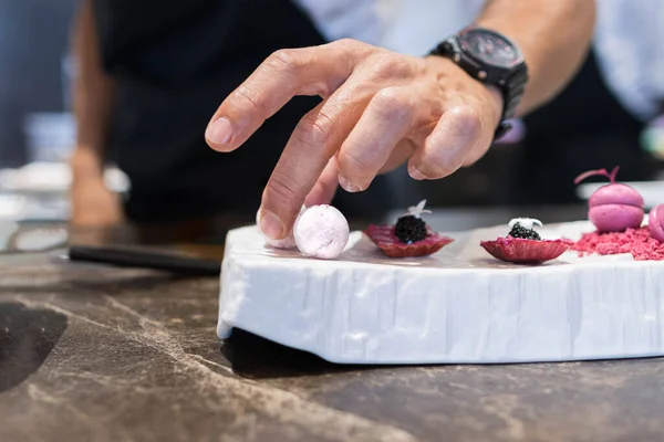 Bir şefin el fotoğrafı müşterinin gastronomik yemeğini bitiriyor..