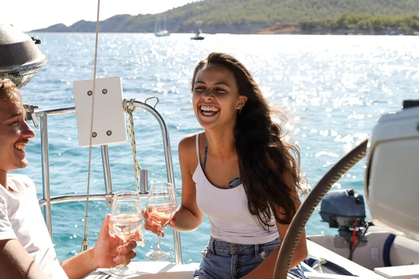 年轻漂亮的姑娘和男朋友度假时在帆船上喝一杯酒 — 图库照片