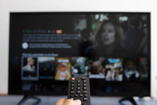 Televizyona bir film koyarken uzaktan kumandayı tutmak