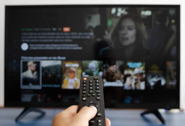 Hand Holding Remote Control While Putting Serie Television — Stock Photo, Image