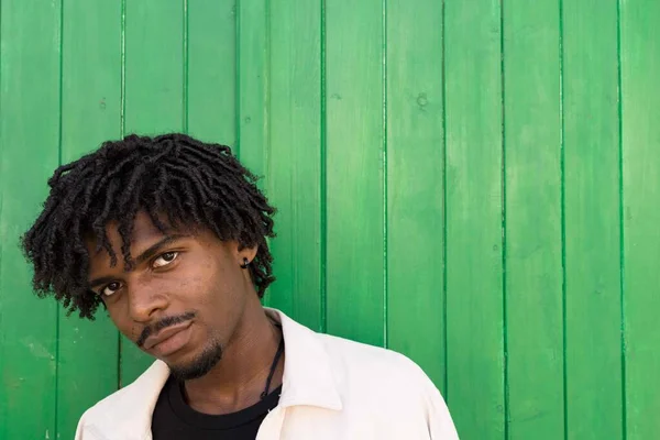 Młody Afro Kręconymi Włosami Patrzący Kamerę Zielone Tło Przestrzeń Kopiowania — Zdjęcie stockowe
